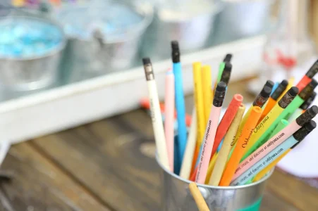 Container holding colored pencils on a desk.